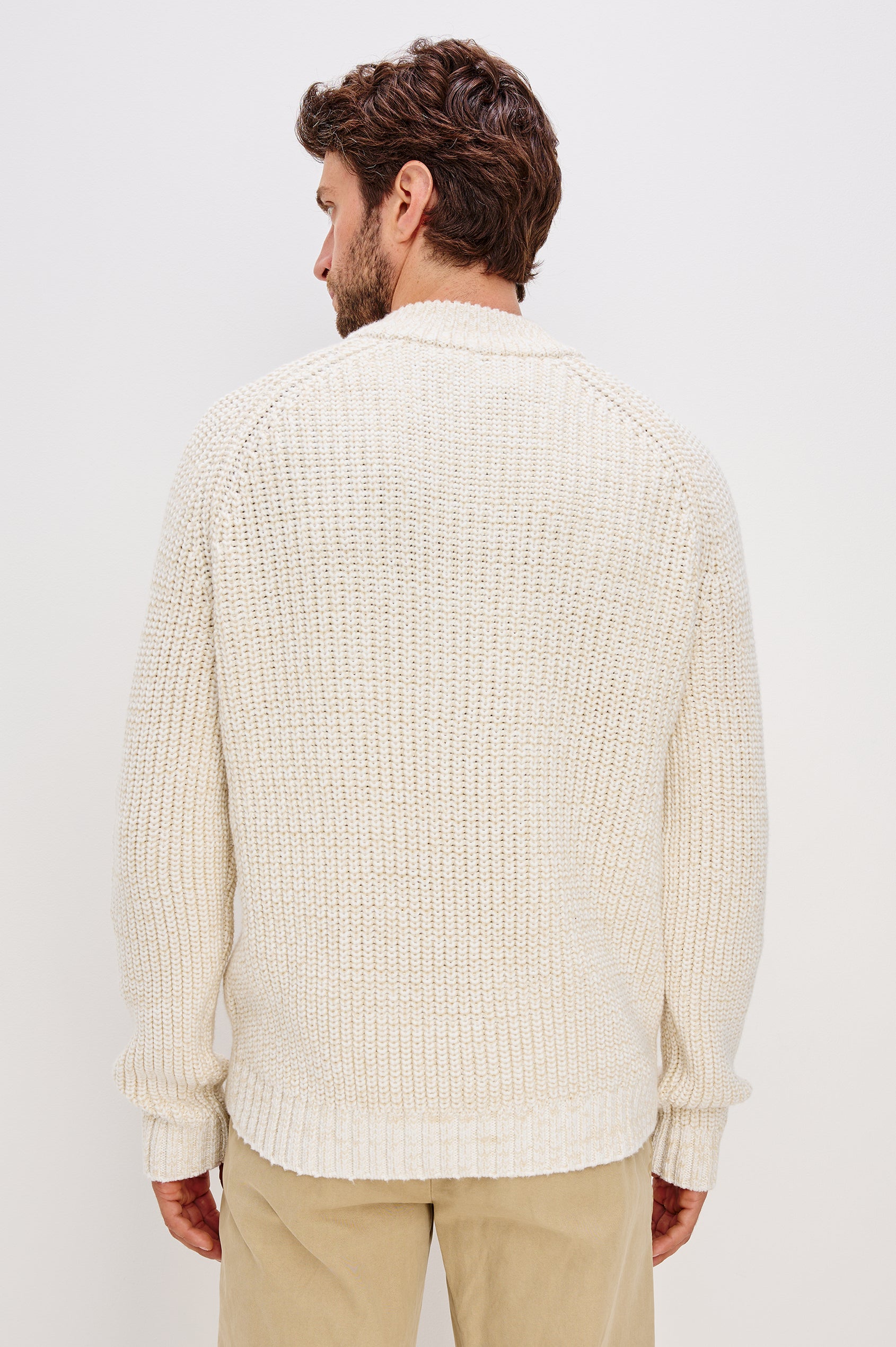 Stratton is a quarter-zip long sleeved sweater knitted from chunky cotton blend knit in Snowdrift Marl colorway. Back view featured on model.