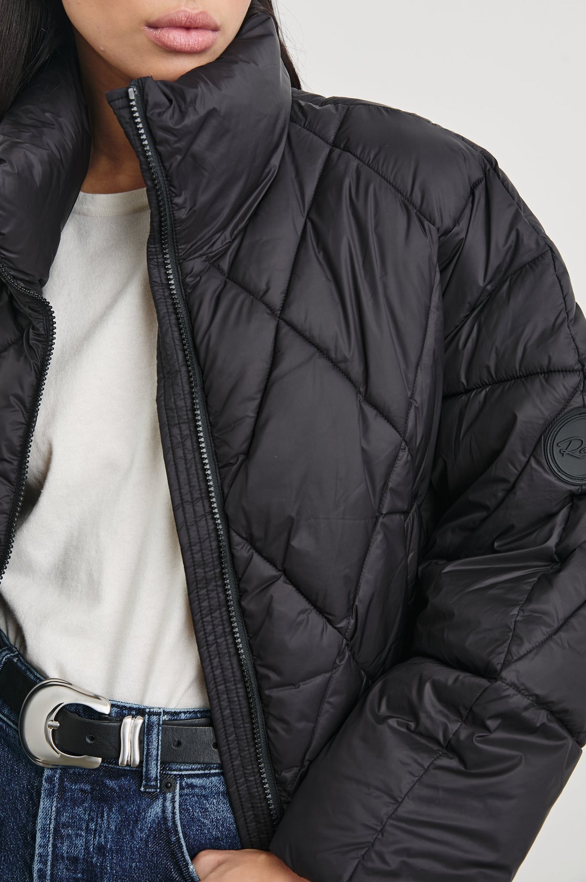 Summit Cropped Puffer Jacket with a Mid-Neck Collar, Two Pockets and a Rails Logo on the Arm in Black Colorway - Front View Featured on Model