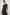 Syd Ribbed, Sleeveless Midi Dress with Wide Shoulder Straps, a Side Slit, and a Cutout that Spans the Lower Back in Black Colorway - Front Full Body View Featured on Model  