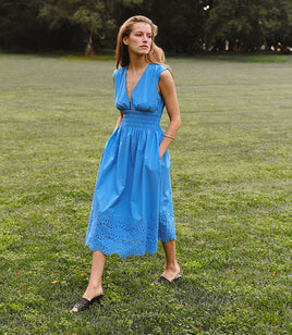 Woman in a blue dress standing in a grassy field