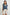 Tafia Top with an Open V-neck, Short Ruffle Cap Sleeves, and a White Blanket Stich along the Neckline, Cuffs and Yoke Seam in Classic Blue Colorway - Front Half-Tucked View Featured on Model