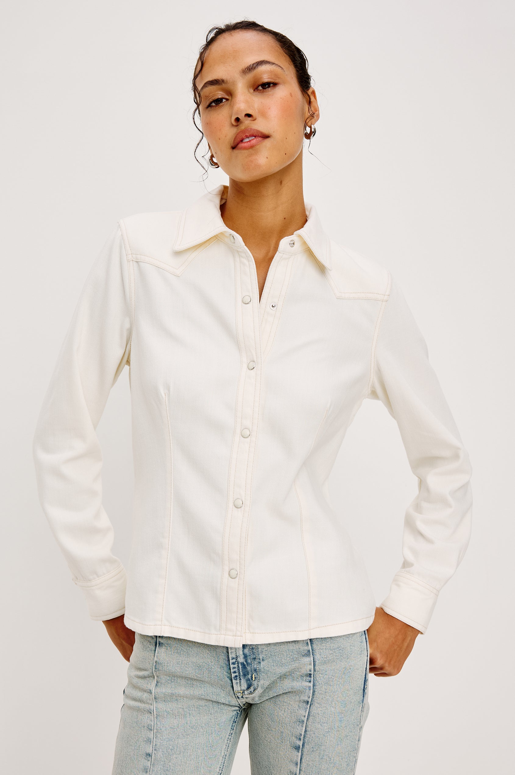 Taiana Shirt in Cotton Lyocell Denim With Collar Front and Back Darting Western Yoke Front Snap Buttons Long Sleeves and Fitted Silhouette in Ivory Colorway - Upper Body Front View Featured on Model