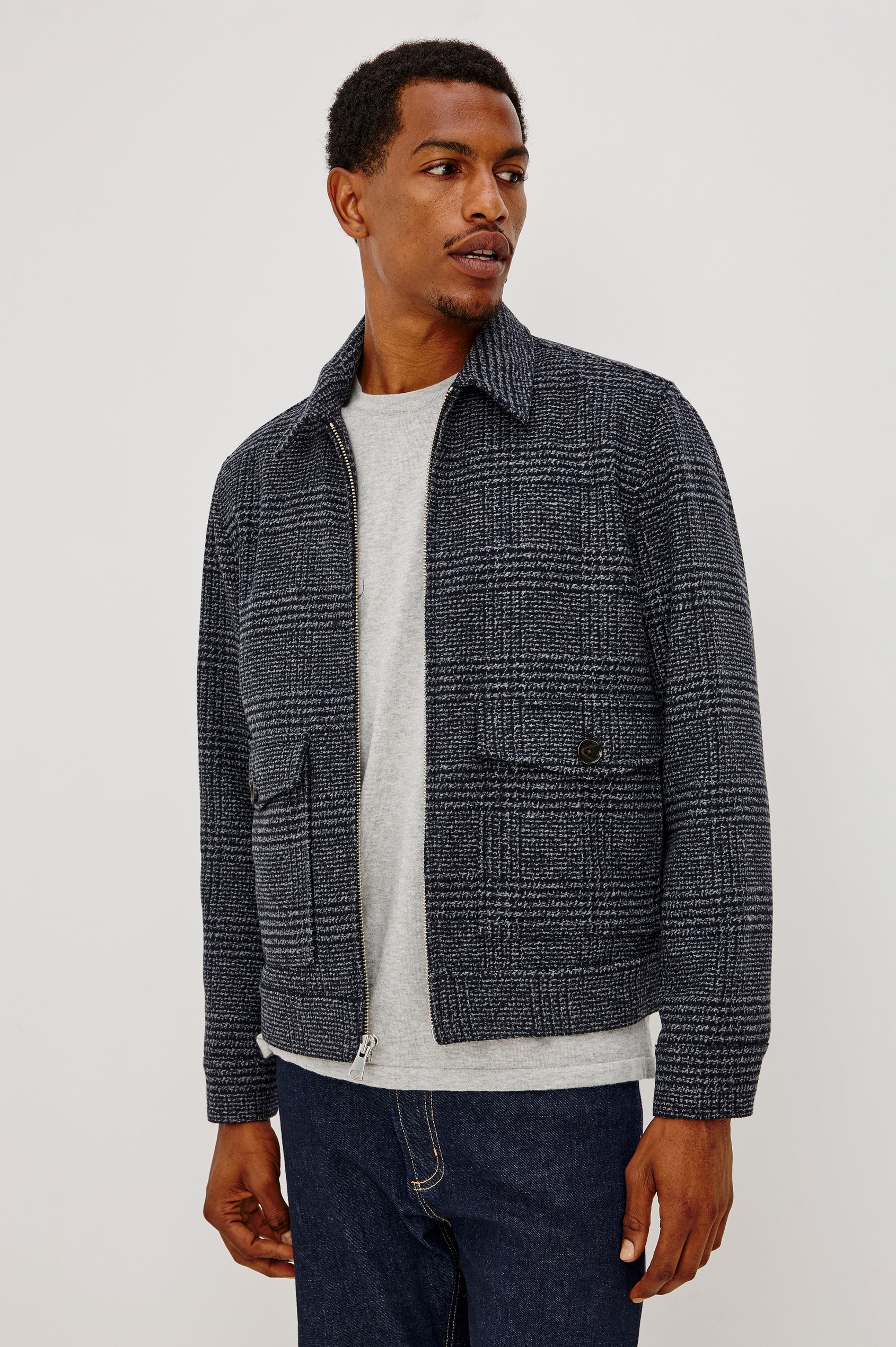 Tillman Jacket in Midweight Textured Wool Blend With Full Custom Lining, Front Zip, Spread Collar, Front Flap Side Entry Pockets, Relaxed FIt, and Long Sleeves in Navy Static Plaid Colorway - Front View Featured on Model.