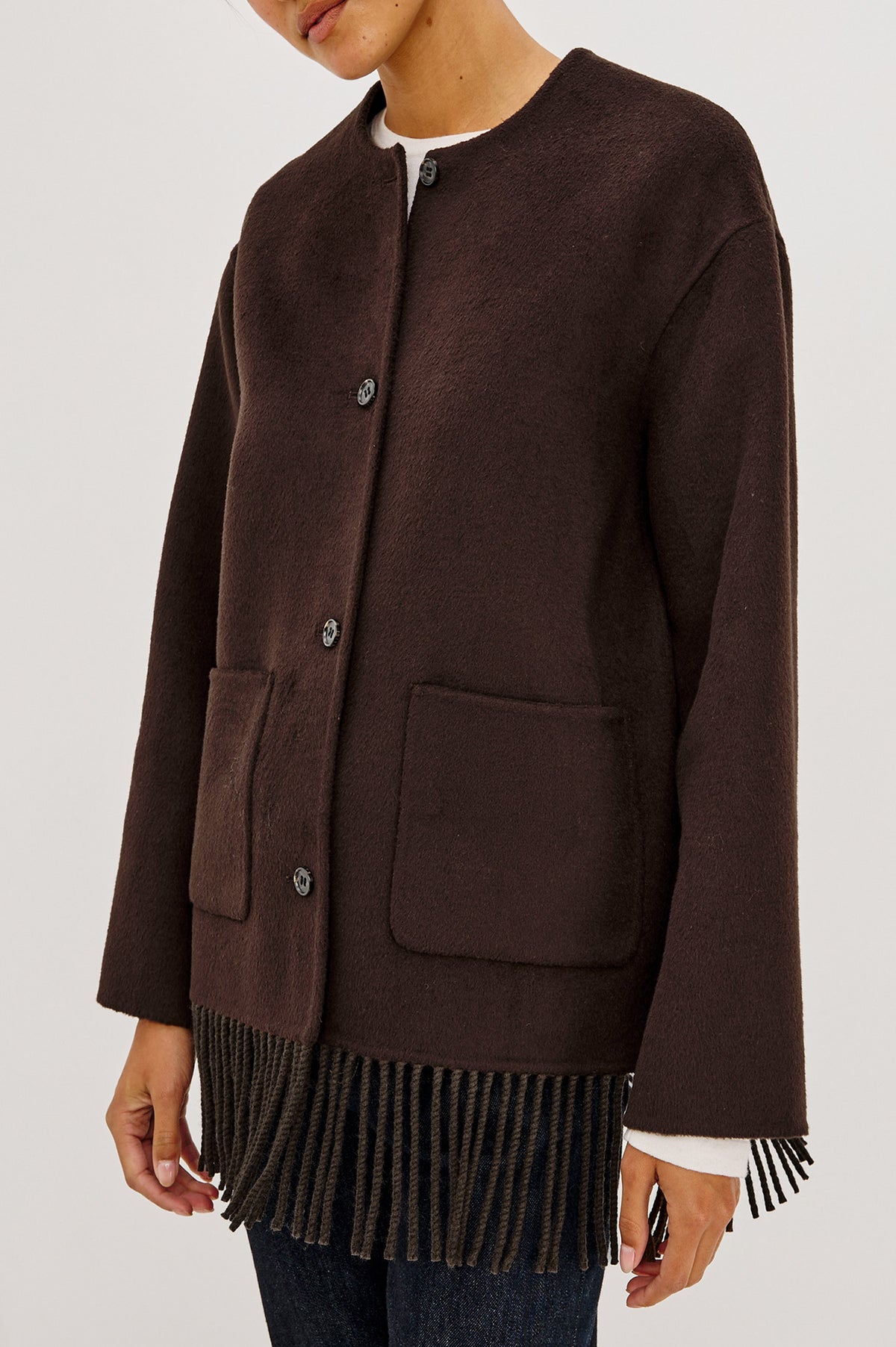Tomoko Jacket in Heavy Wool Blend With Collarless Neckline, Front Buttons, Front Patch Pockets, and Fringe Hem in Chocolate Colorway - Side Crop Detail View Featured on Model.