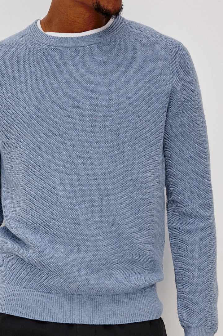 Vann long sleeve crew neck sweater in Light Blue Heather Colorway. Front Detail View on Model Shown.