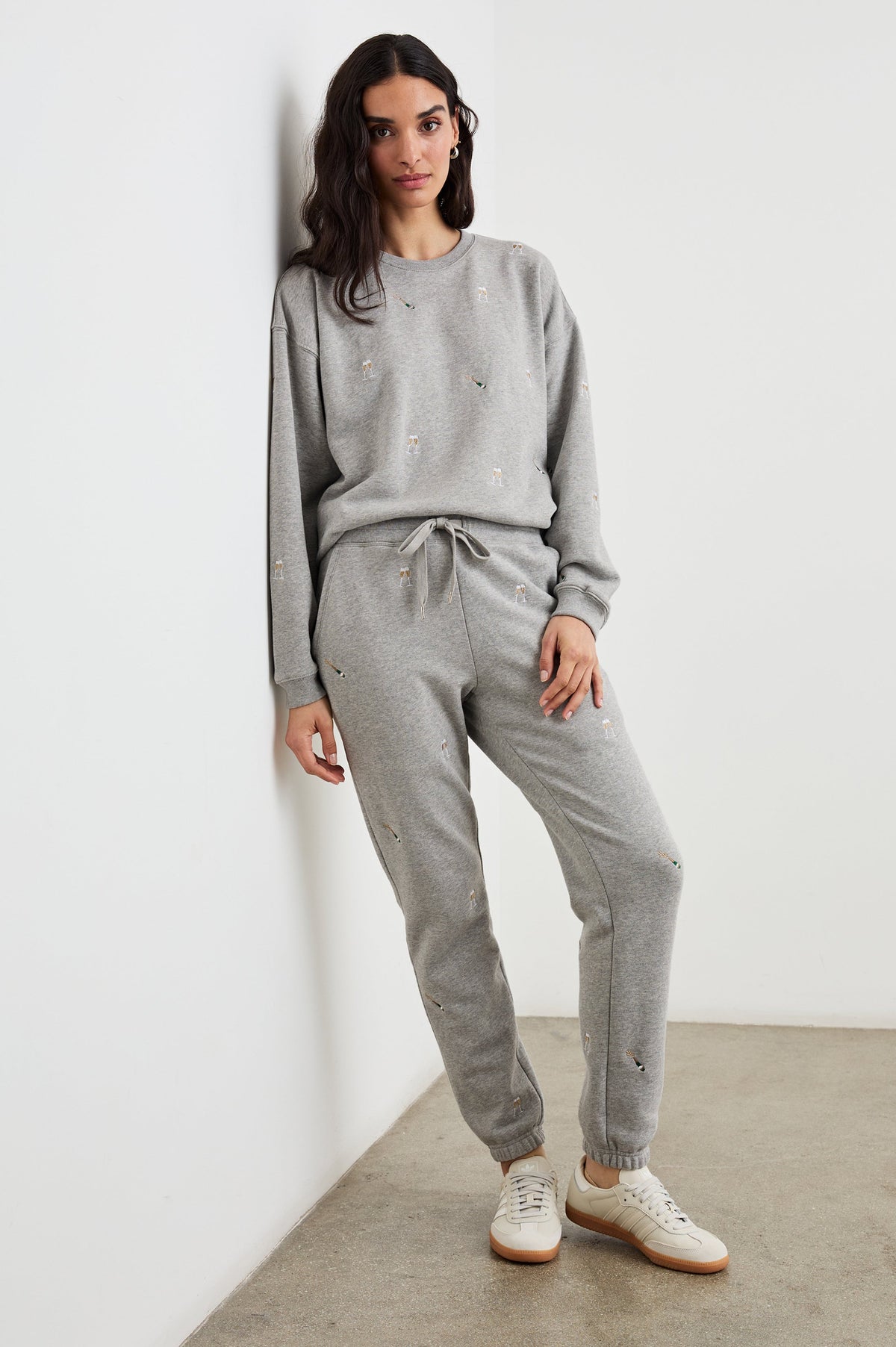 The Varsity Sweatshirt with a Crew Neck and embroidered Champagne Glasses in Champagne Embroidery Colorway, on light grey - Front Full Body View Featured on Model 