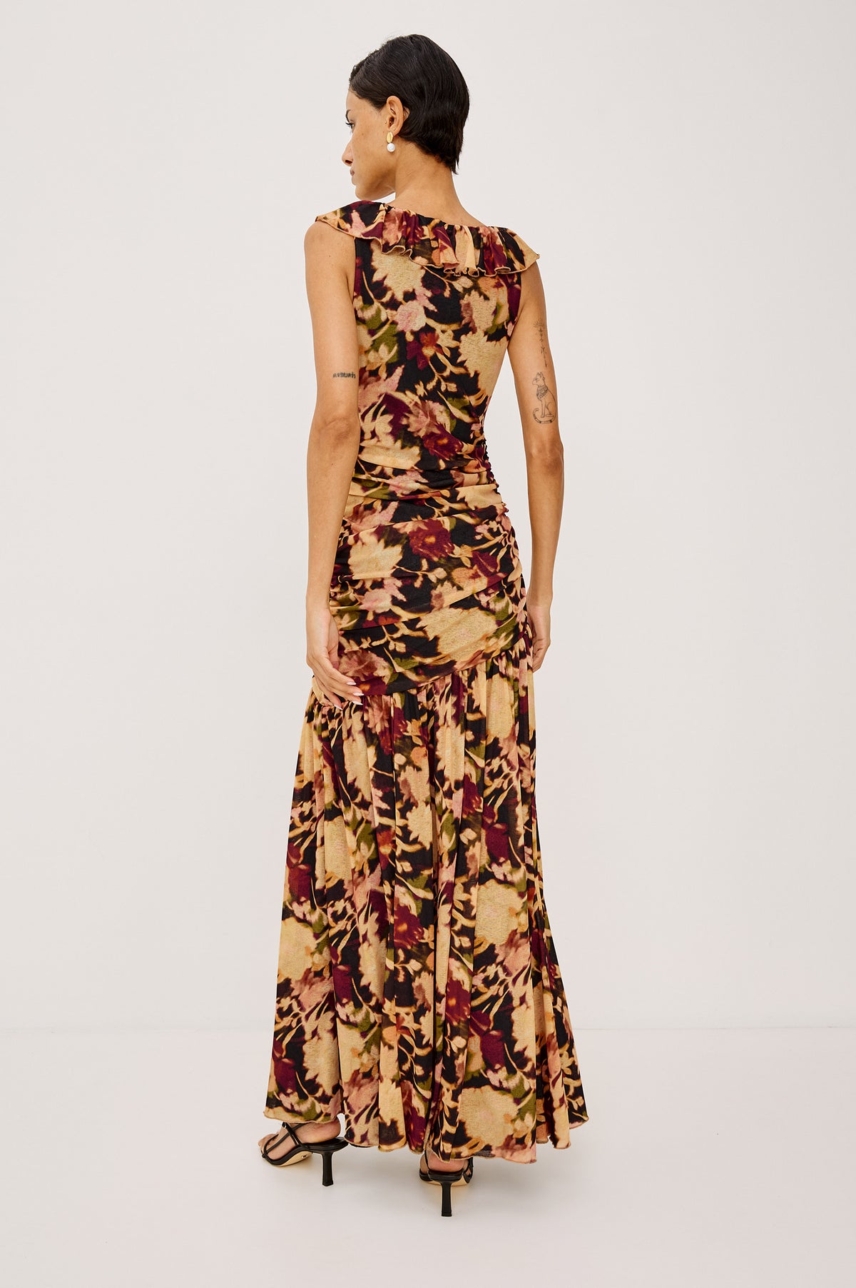 Veda Maxi Dress in Self-Lined Mesh With Sleeveless Cut, Full Lining, Ruffle V-Neckline, Ruched Bodice, and A-Line Skirt in Dark Flora Colorway - Full Body Back View Featured on Model