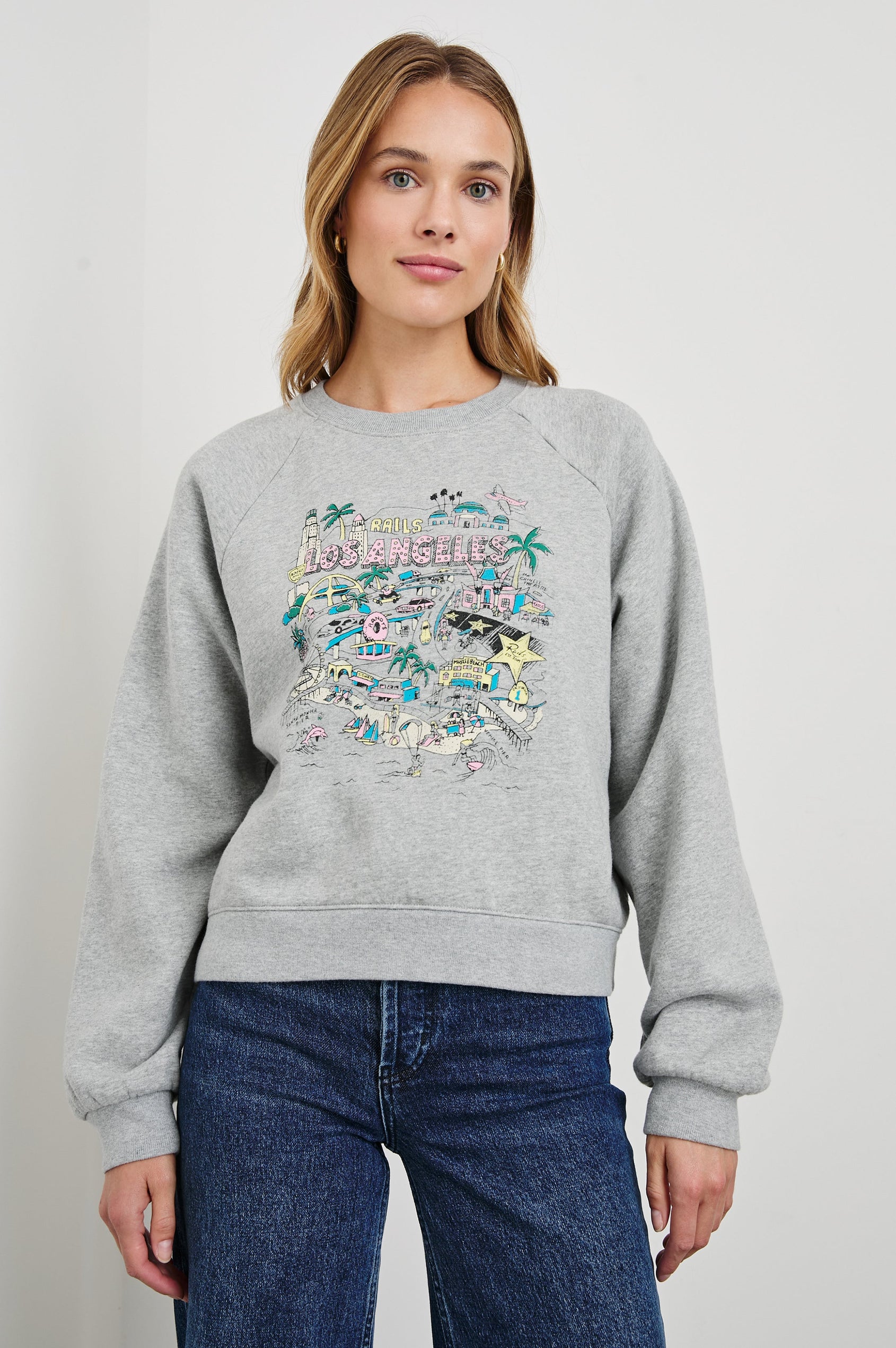 Vintage Raglan Long-Sleeve Sweatshirt with a Crew Neck, an image of landmarks in Los Angeles and the Text, Rails Los Angeles in Rails Los Angeles Map Grey Colorway, Mostly Pink, Yellow and Blue on Grey - Front View Featured on Model