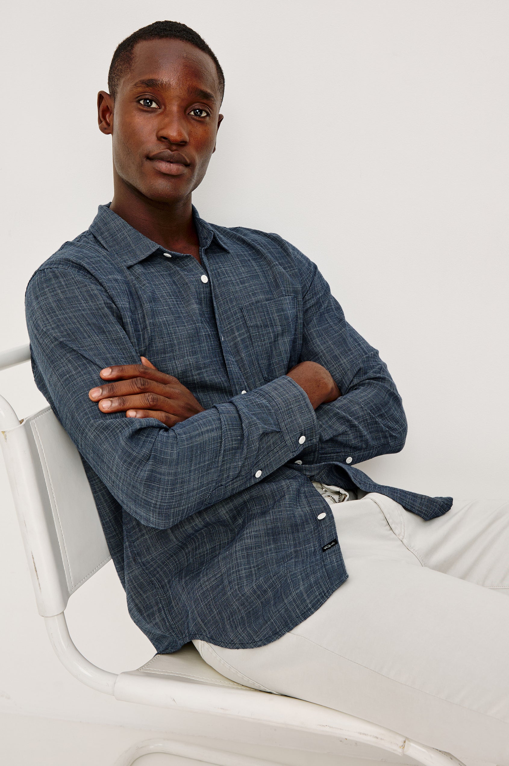 Wyatt Button Front Collared Shirt With Long Sleeves and Single Chest Pocket in Navy Etch Colorway - Upper Body Front View Featured on Model Sitting