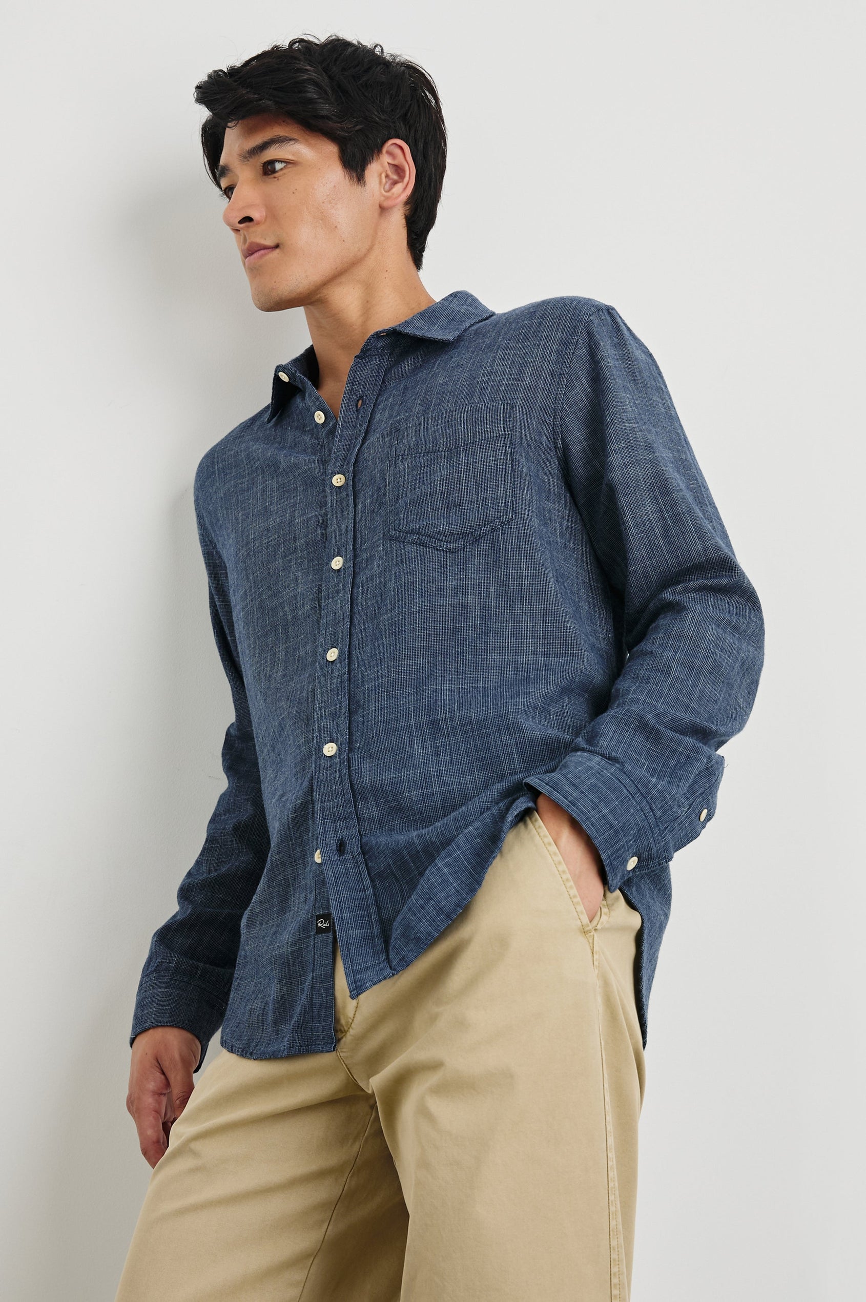 Wyatt Long-Sleeve Relaxed Fit Button Up with a Chest Patch Pocket in Navy Etch Colorway - front view on model, leaning against wall