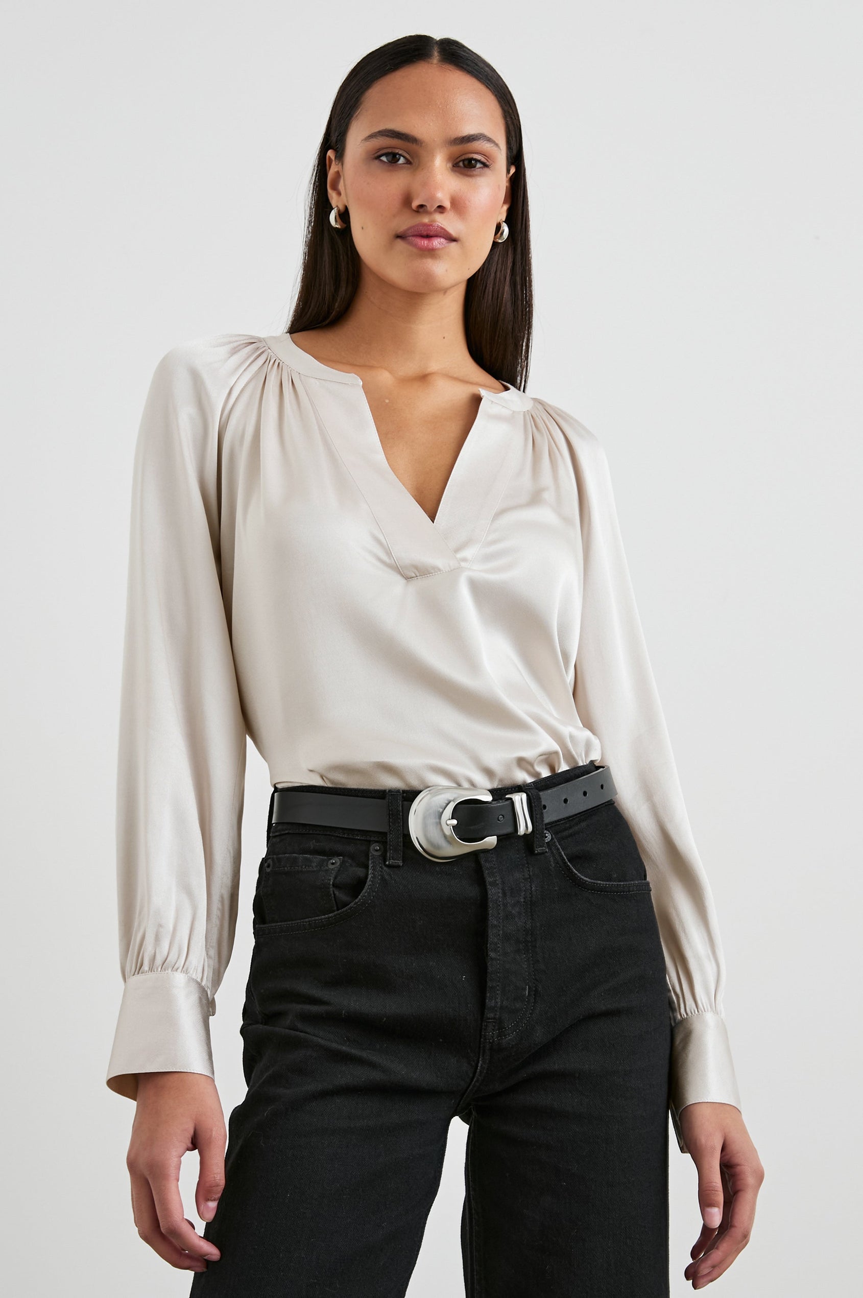 Wynna Long-Sleeve Top with a Deep V Neck and Ruching above the Cuffs and at the Neckline in Ivory Colorway - Front Tucked View Featured on Model