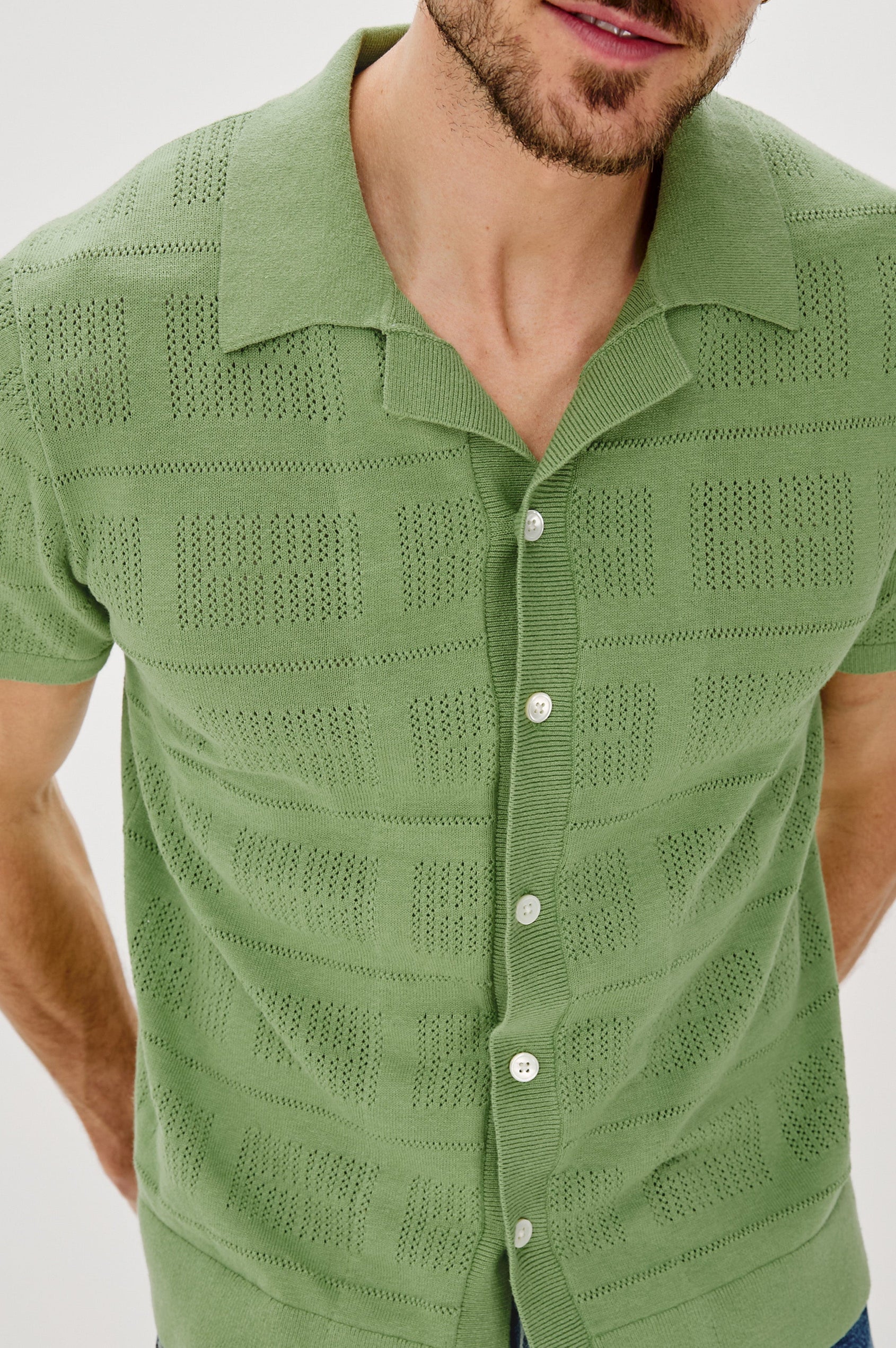Yates Button Front Knit Shirt with Short Sleeves, a Relaxed Collar and Lapel, Ribbed Sleeve Cuff, Collar, Hem and Front Button Placket in Cream Colorway. Front Detail View Shown on Model.