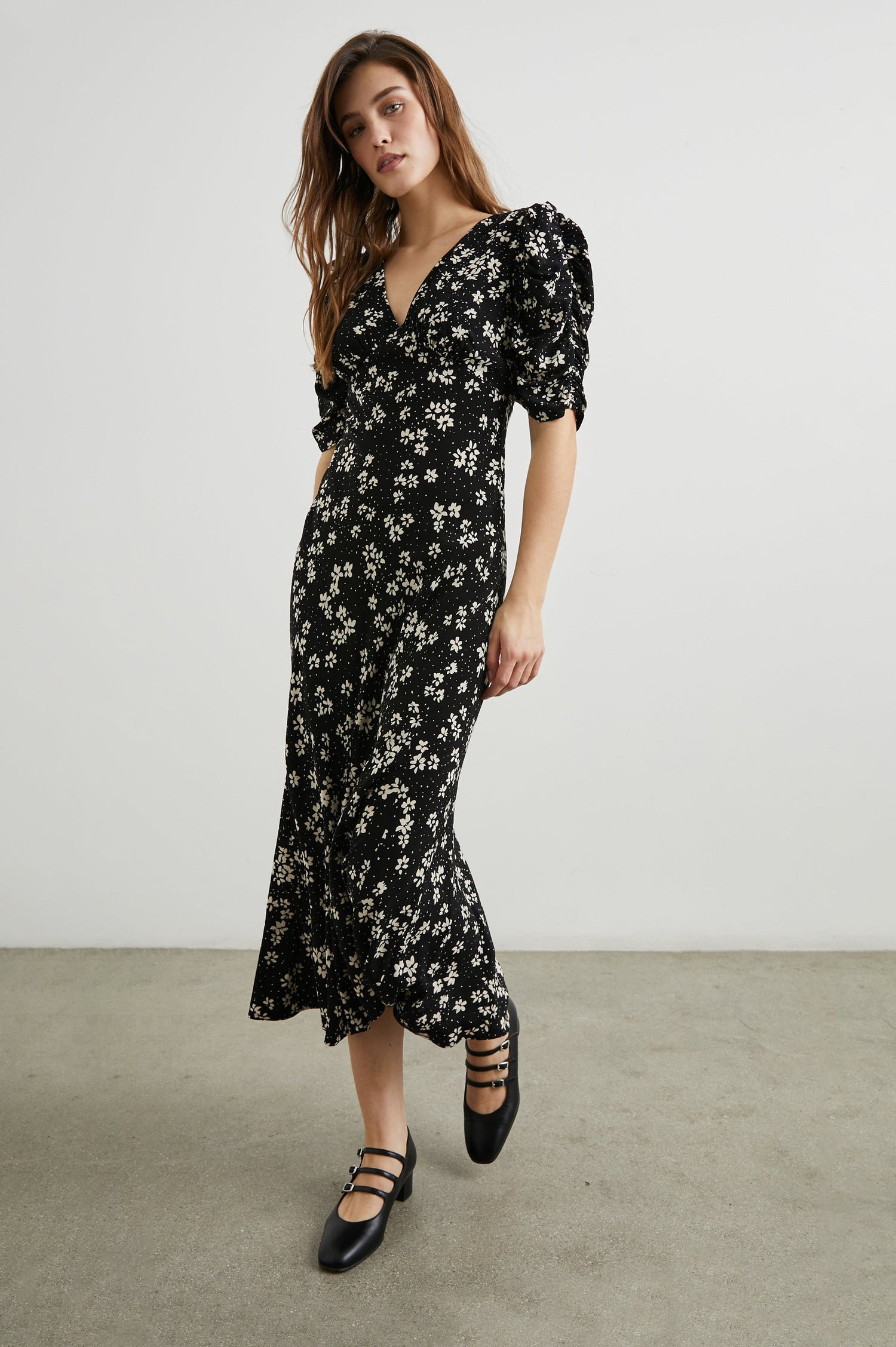 Zariah Midi Dress with Mid-Length Sleeves with Light Ruching, a Deep V Neck and an Empire Waist in Noir Floral Colorway, with white flowers on black - Front Full Body View Featured on Model
