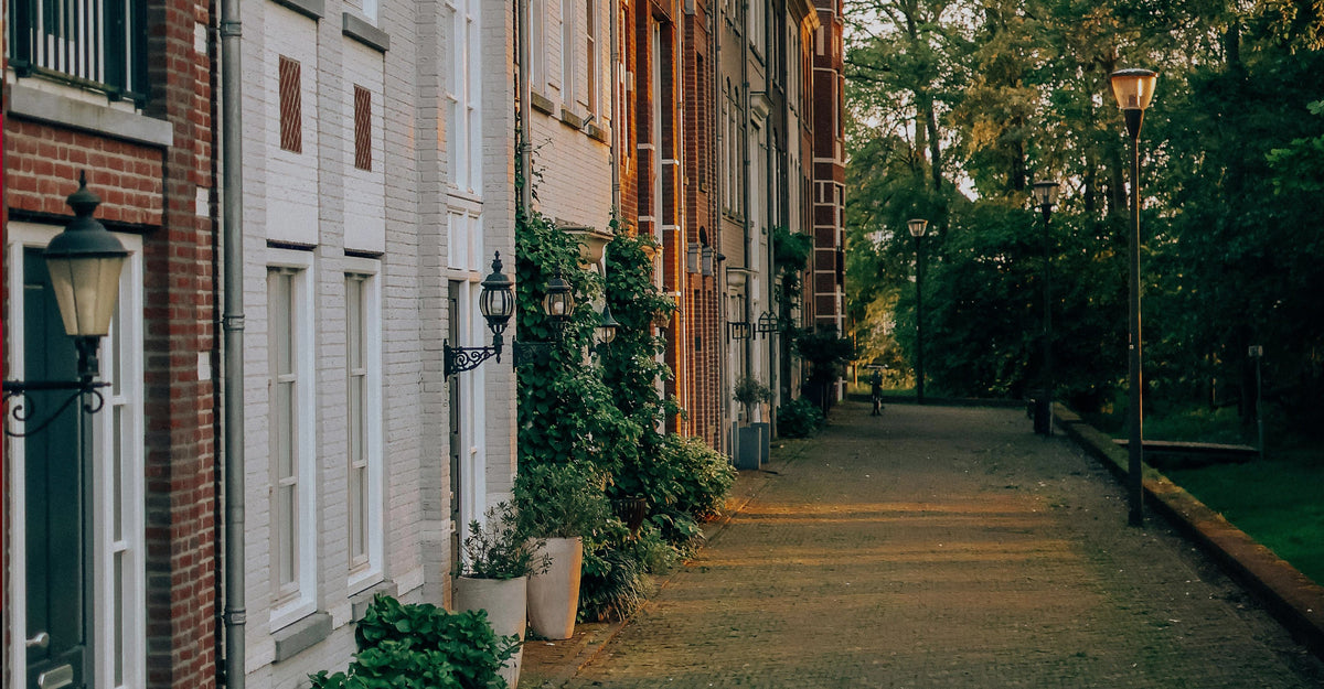 A SIDE WALK ALONG A ROW OF TOWNHOMES SHOWING STREET LIGHTS AND TREES