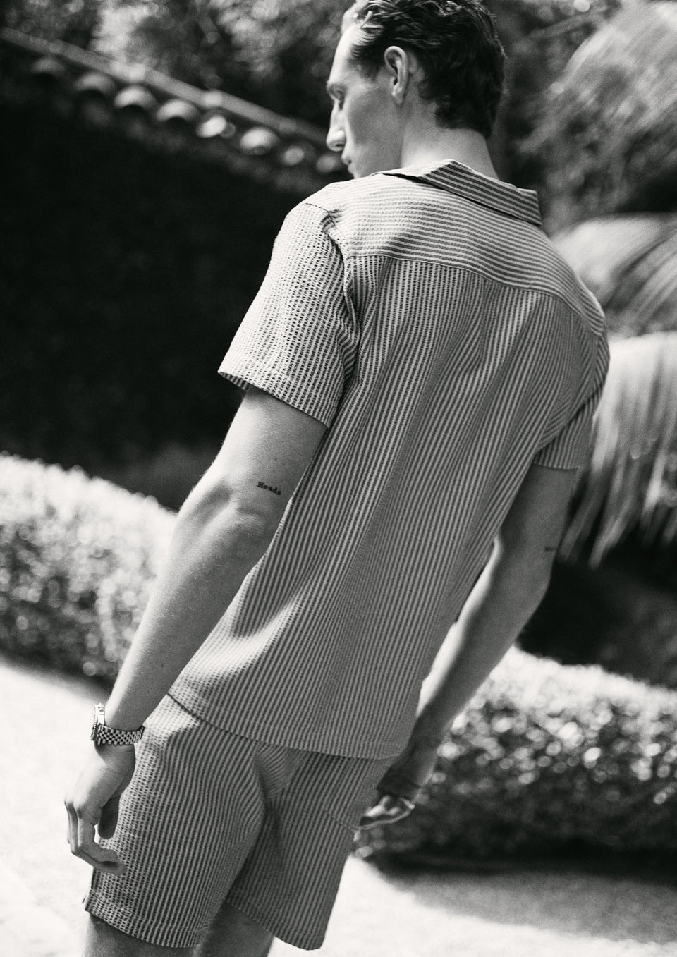 Man wearing a striped shirt and shorts in an outdoor setting