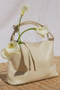 Siena Slouchy Hobo Bag in Italian Leather With Knotted Top Strap, Zipper Closure With Fringe Tassel And Interior Snap Button Slip Pocket in Bone Colorway - Video - Front View Featured stylized with flowers in purse.