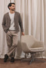 Adair Cardigan in Alpaca Wool Nylon Blend With Chevron Texture, V-Neck, Front Buttons, and Long Sleeves in Pine Log Colorway - Full Body View Featured on Model Posing with Chair (Video).