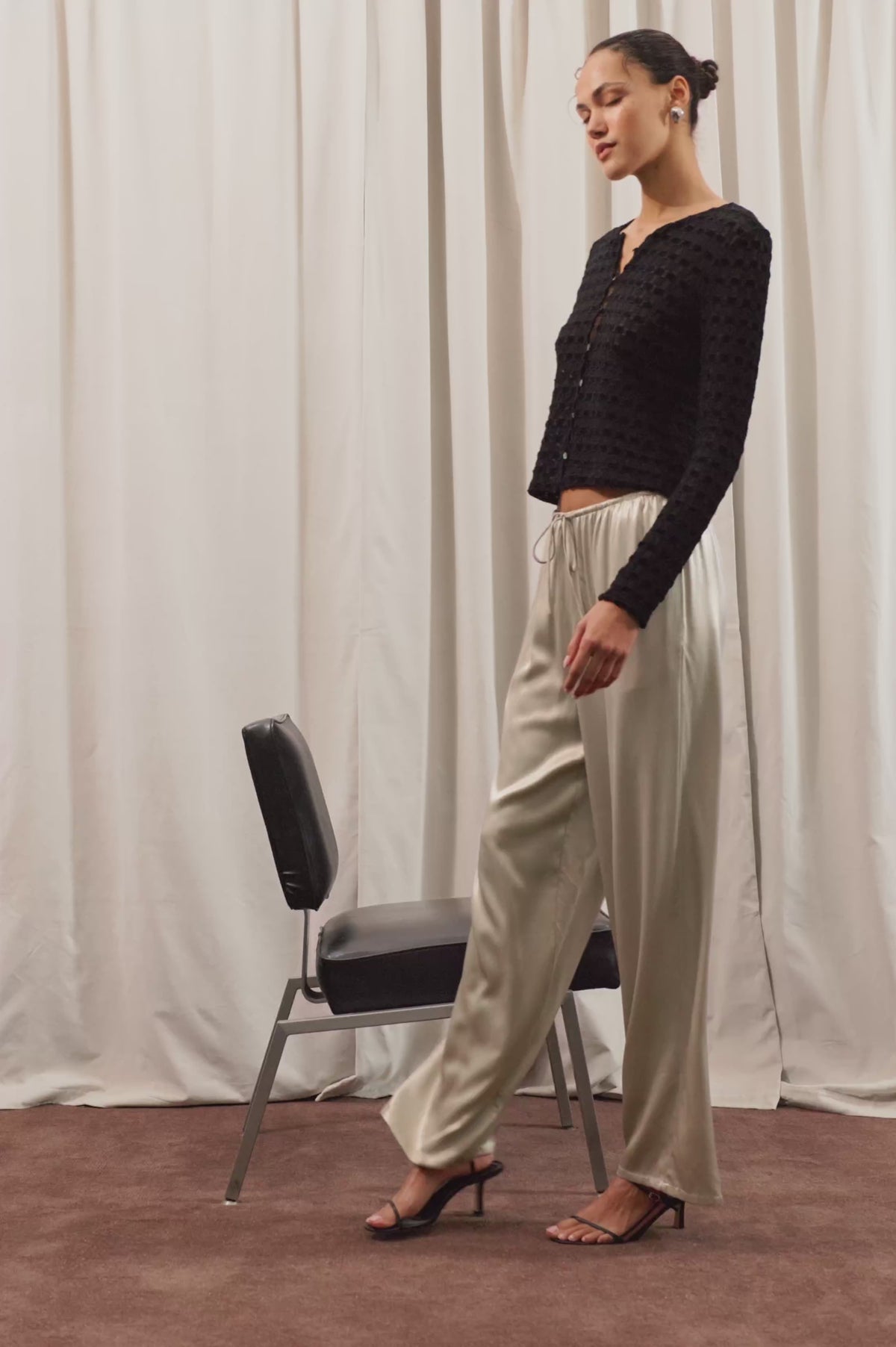 Virgo Pant in Satin-Back Crepe With Straight Legs, Drawstring Waist, and Side-Seam Pockets in Mink Colorway - Full Body View Featured on Model Posing with Chair (Video).